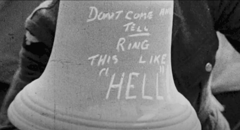 Black and White Photograph of a bell that says Don't Come and Tell Ring This Like "Hell"