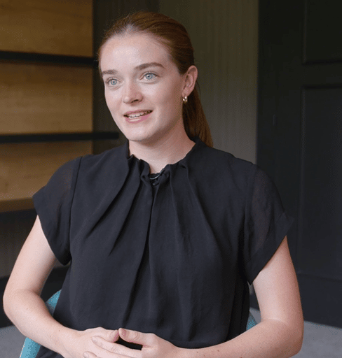 Woman in black top with a ponytail looking off to the side